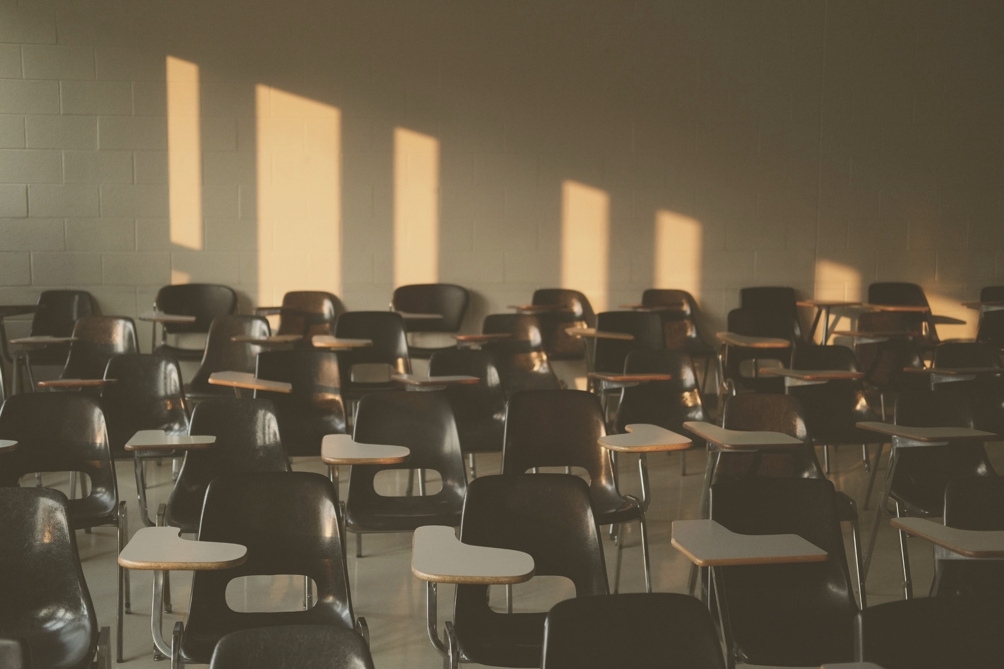 An empty lecture hall, atmospheric light across the seating.